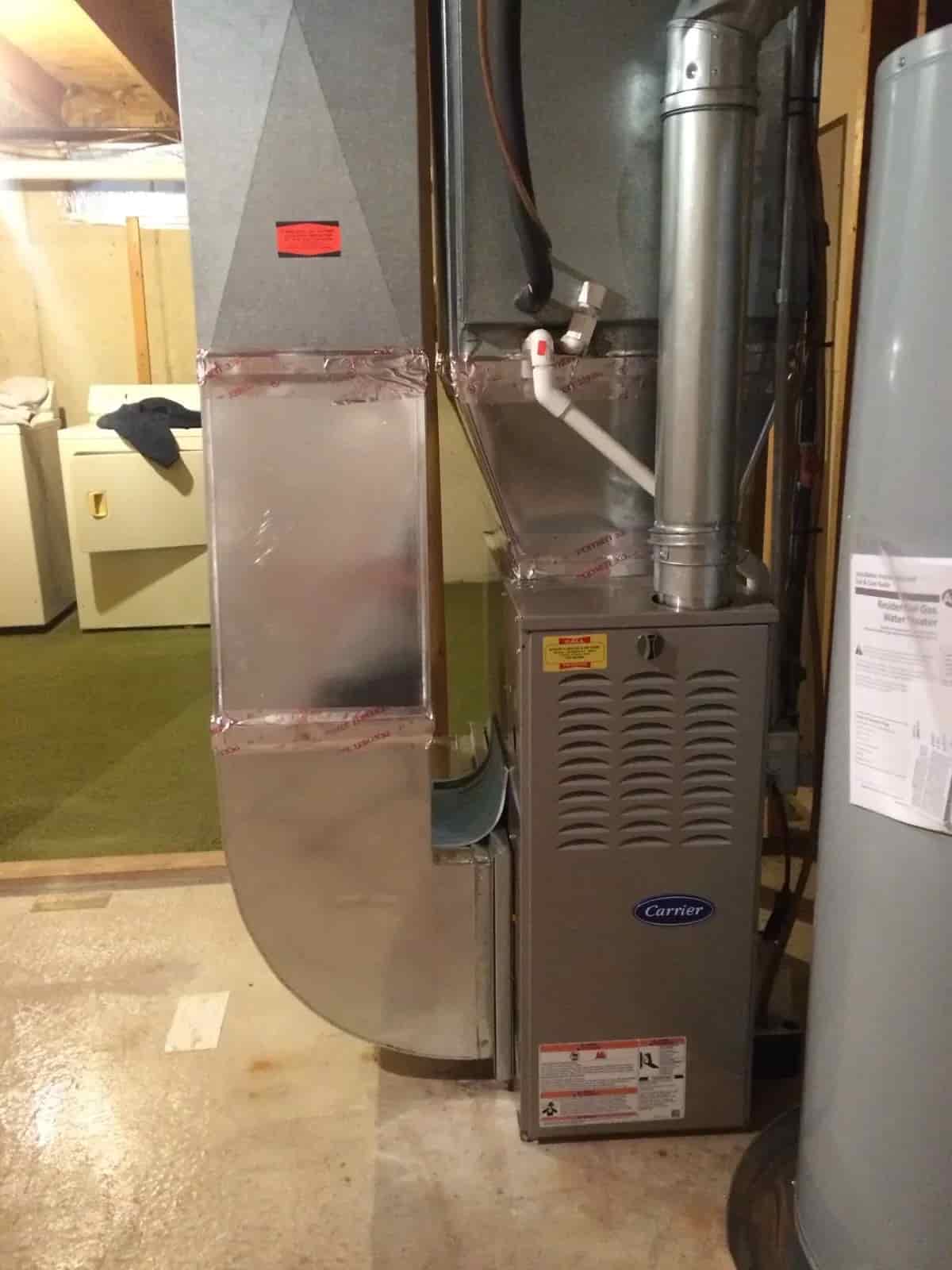 Mazure's technician repairing a Carrier furnace in a West Michigan home
